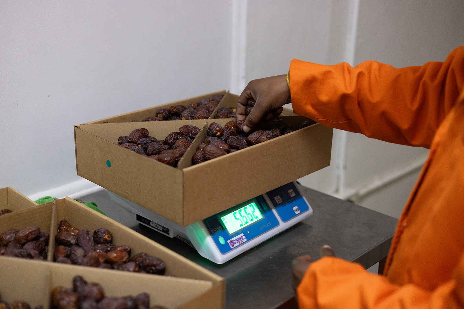 A packed date box being weighed